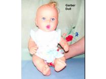 Vintage Gerber Baby Doll with a white cradle and handmade cradle quilt