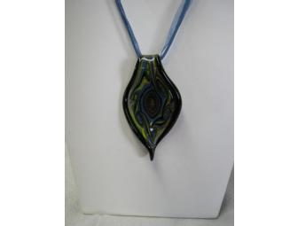 Hand blown glass pendant on blue ribbon.