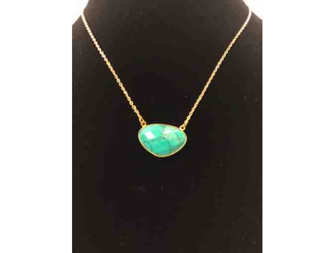 Turquoise colored pendant on  gold tone chain