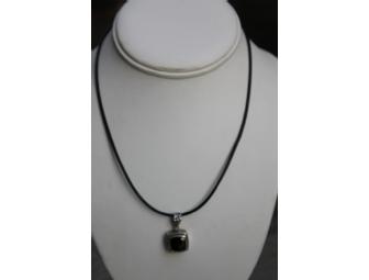 Black Spinel pendant in silver and gold setting on leather cord