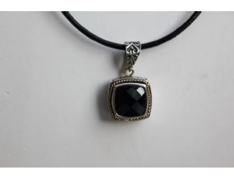 Black Spinel pendant in silver and gold setting on leather cord