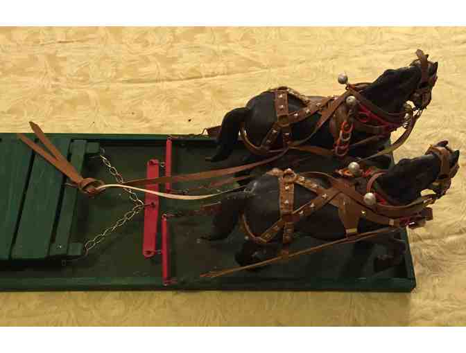 Table top sled with two horses pulling it.