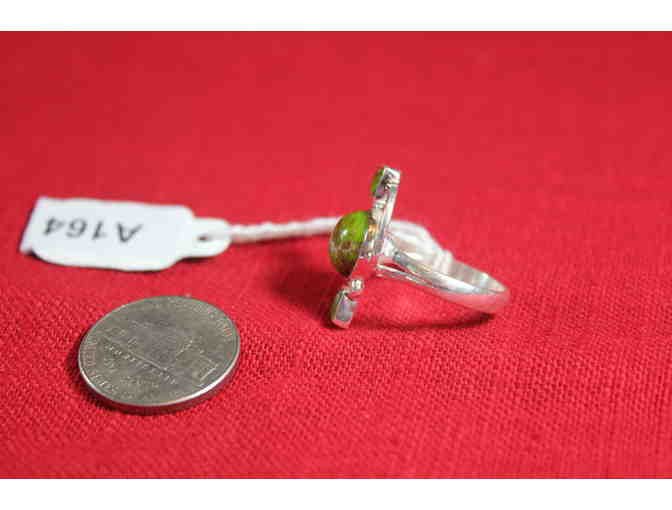 Ring with central round stone flanked by square stones