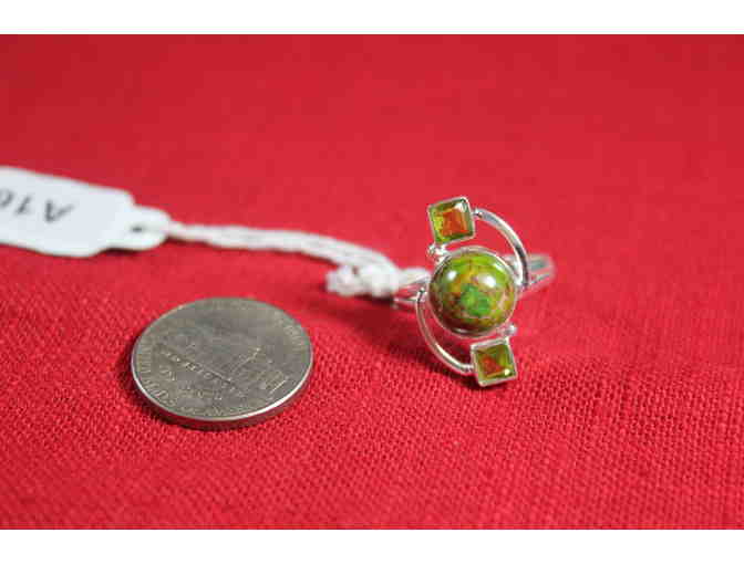 Ring with central round stone flanked by square stones