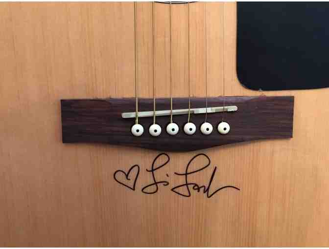 A Fender acoustic guitar signed by Lisa Loeb