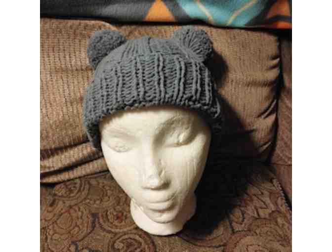Two knitted hats with pom poms