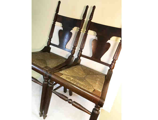 2 antique dark wood chairs with woven seats