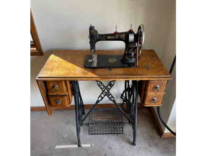 White treadle sewing machine in birdseye maple case with wrought iron stand