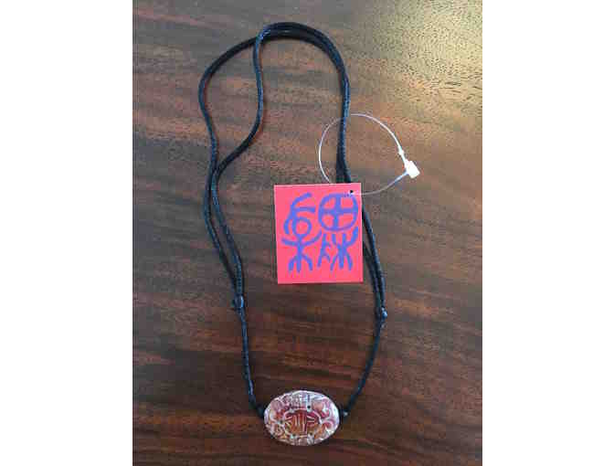 Double-sided carved serpentine amulet necklace.